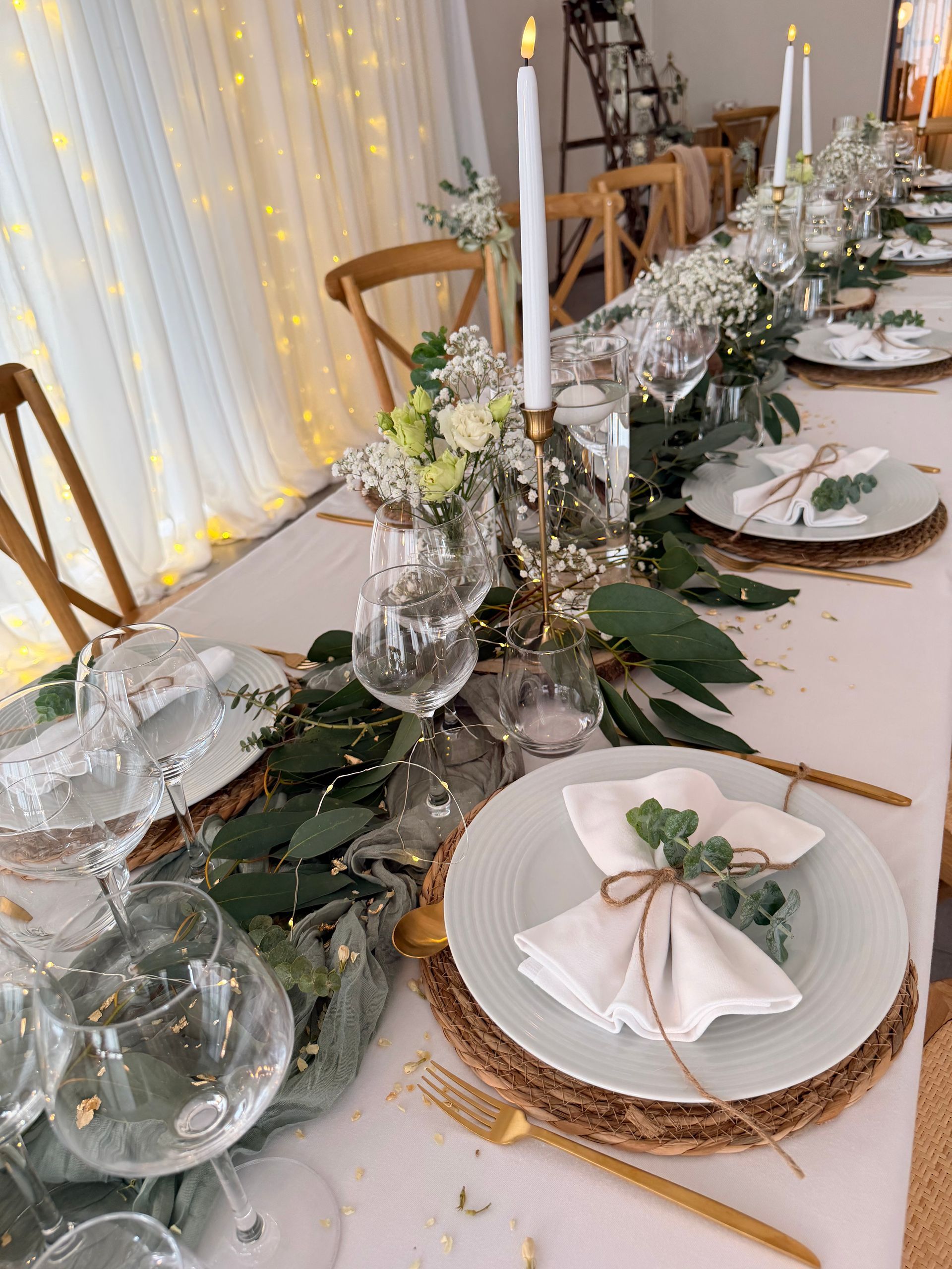 Élégante table dressée avec une serviette blanche pliée dans un anneau doré sur une assiette et des verres.