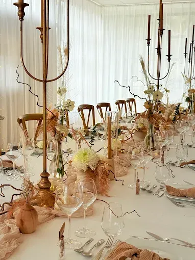 Une table de mariage décorée avec des bougies et des fleurs.