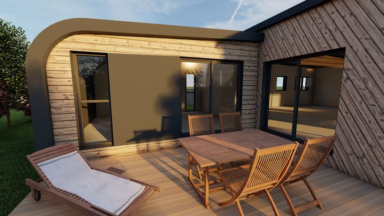 Patio avec des chaises en osier, une table et une chaise longue à l'extérieur d'une maison moderne au coucher du soleil.