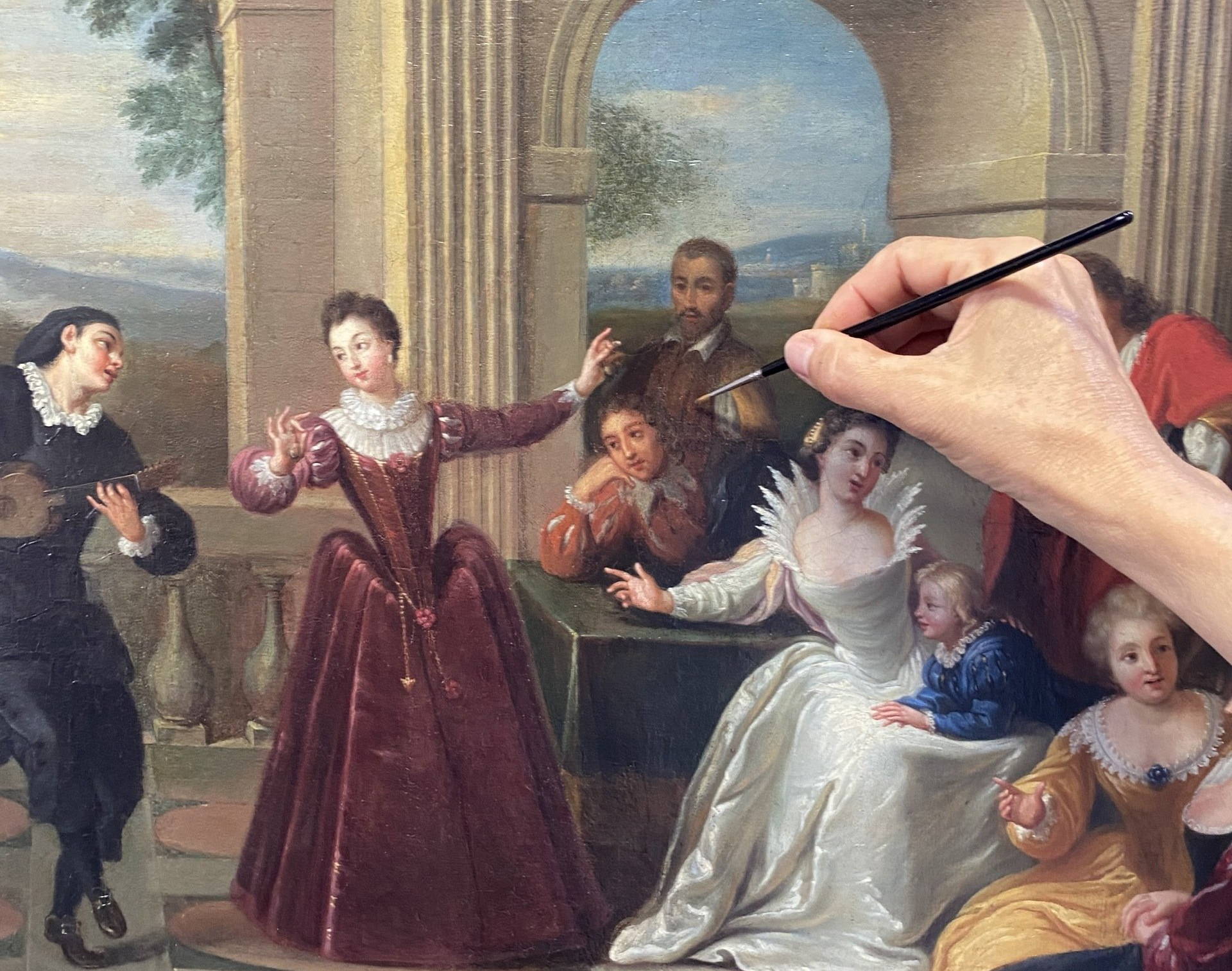 Main peignant un tableau avec plusieurs personnes dessus