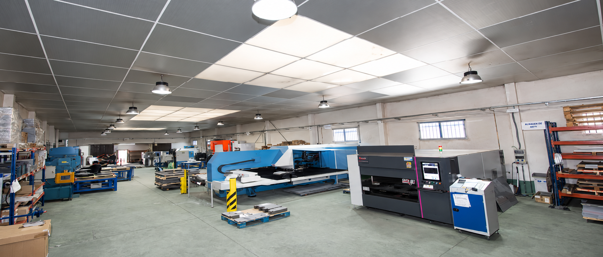 Amplio taller con maquinaria, bancos de trabajo y estanterías en una estancia industrial luminosa