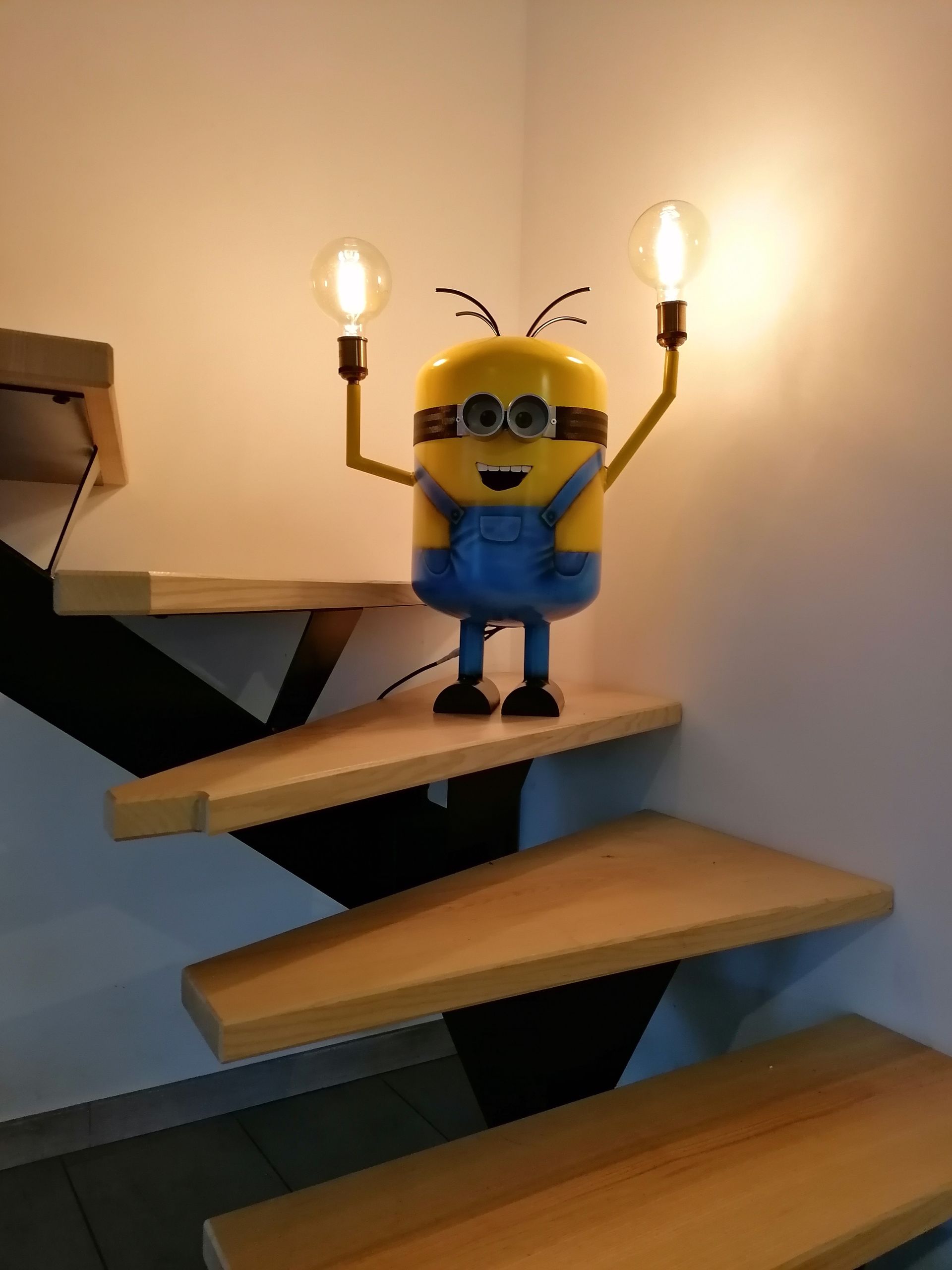 Photo d'un personnage de dessin animé en métal dans des escaliers en bois