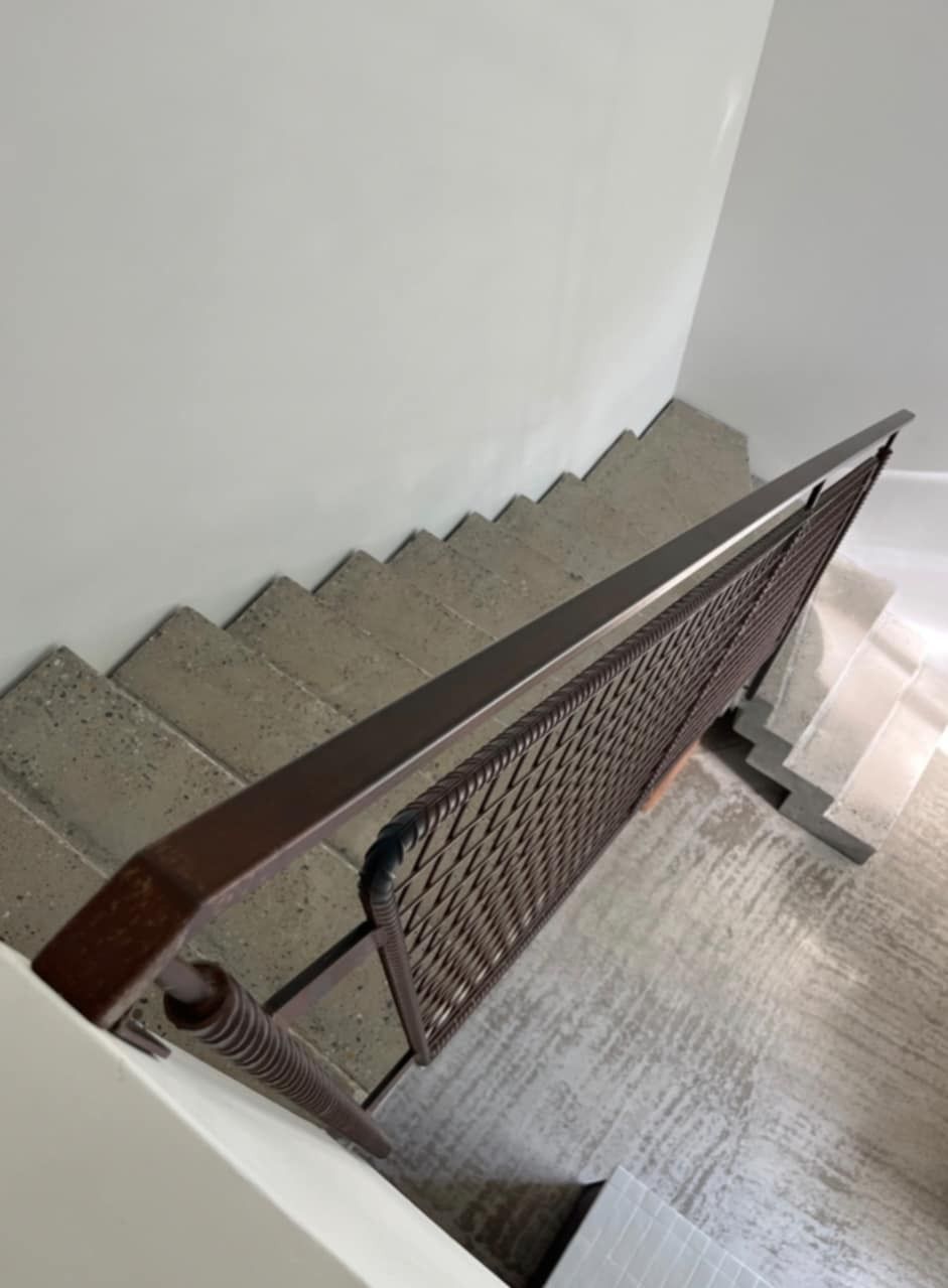 Escalier en béton avec une rambarde en fer forgé