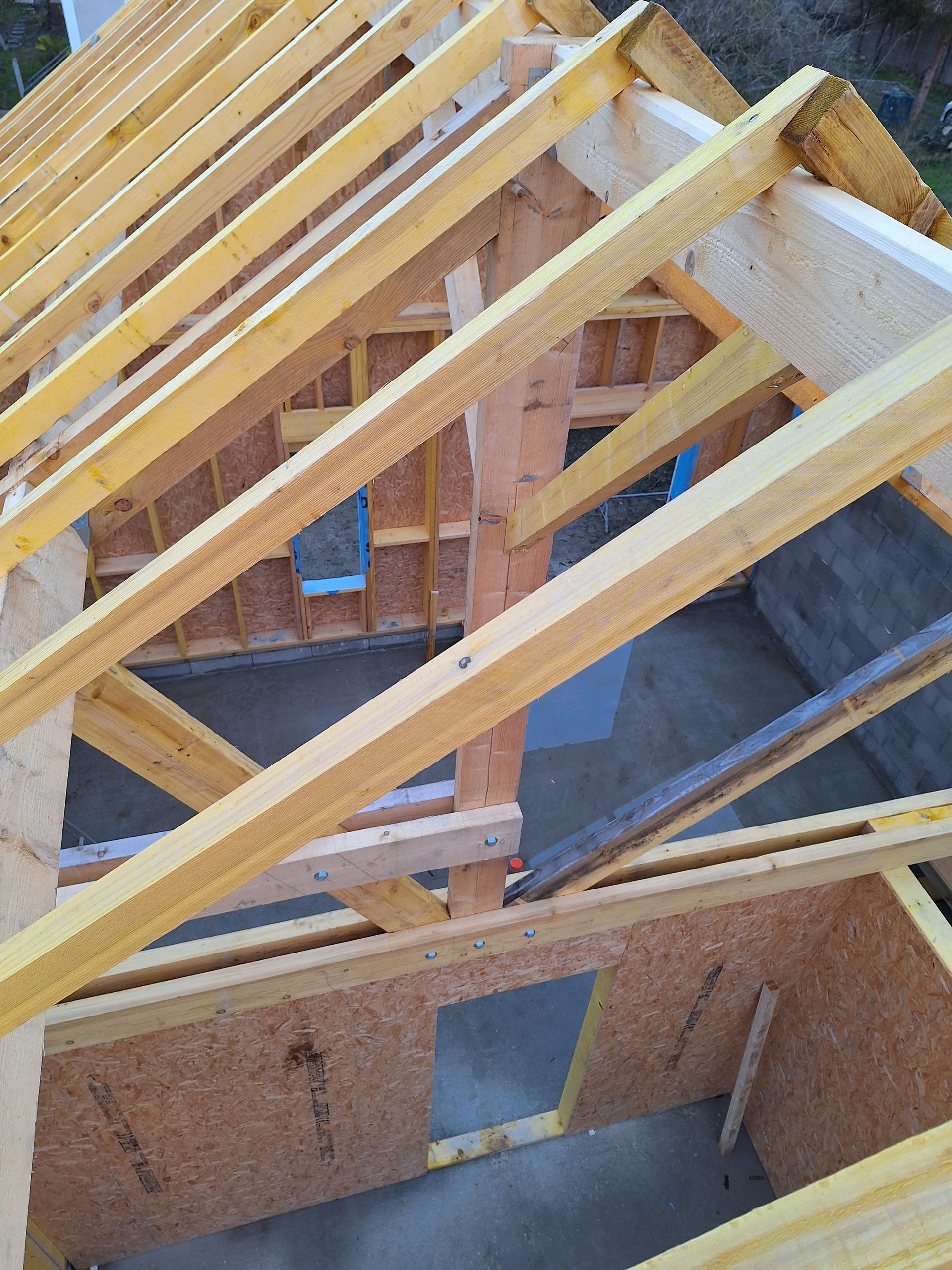 Charpente en bois en construction ; lumière du jour.