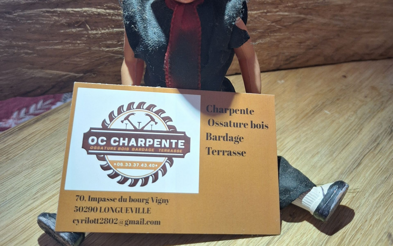 Une poupée tenant une pancarte pour OC Charpente.