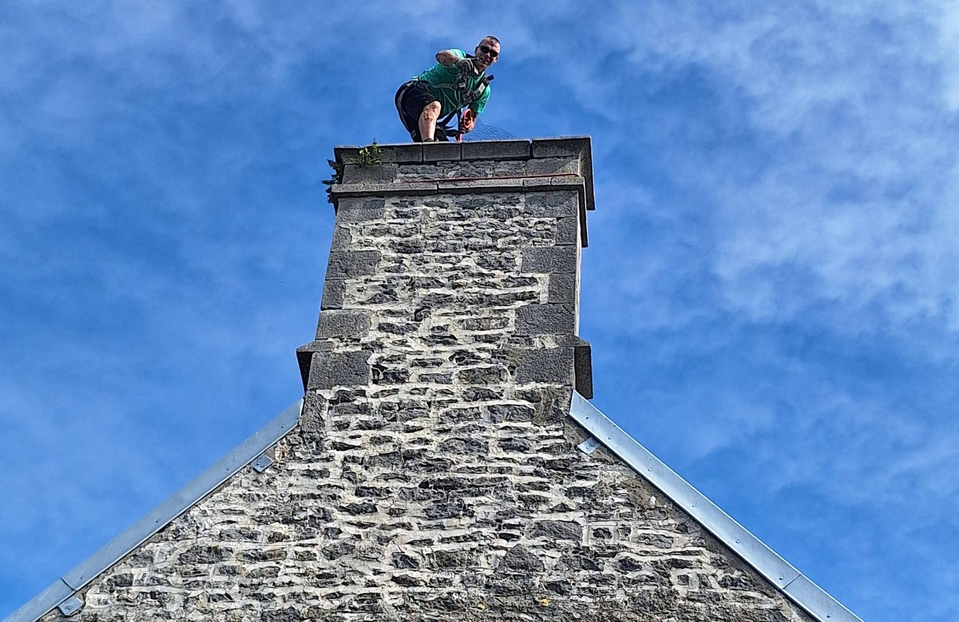 Personne sur une cheminée en pierre, en fond un ciel bleu.