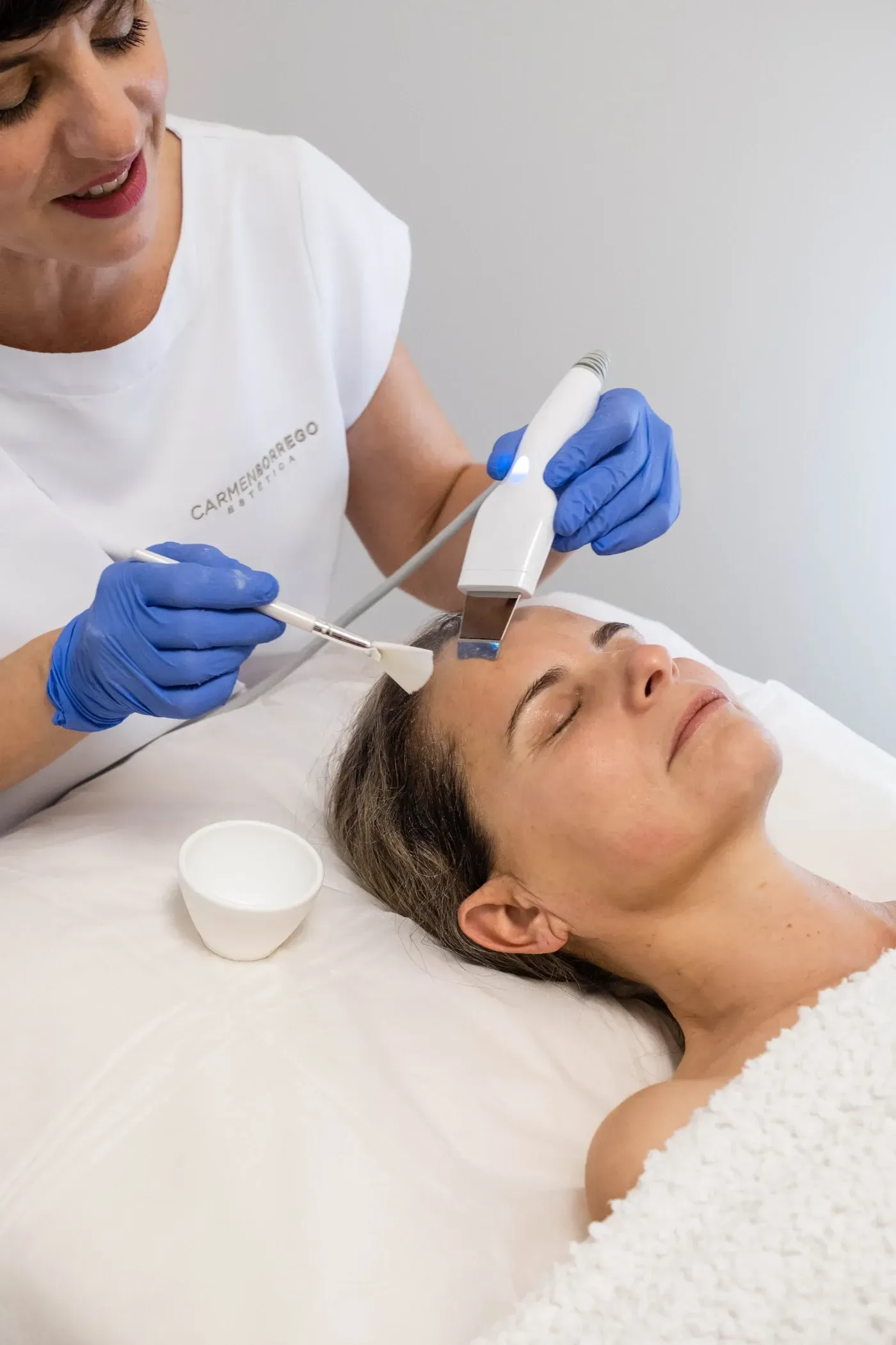 Una mujer está recibiendo un tratamiento facial en un salón de belleza.