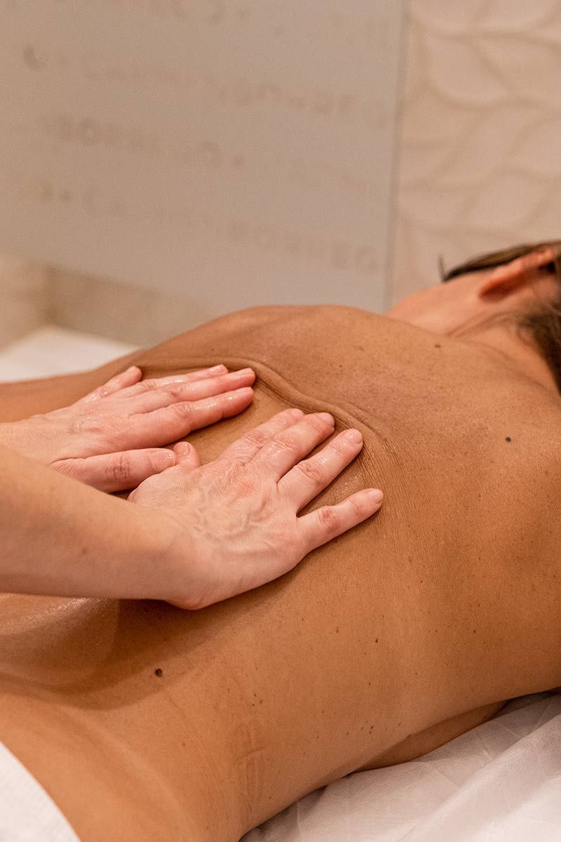 Una mujer está recibiendo un masaje en la espalda en un spa.