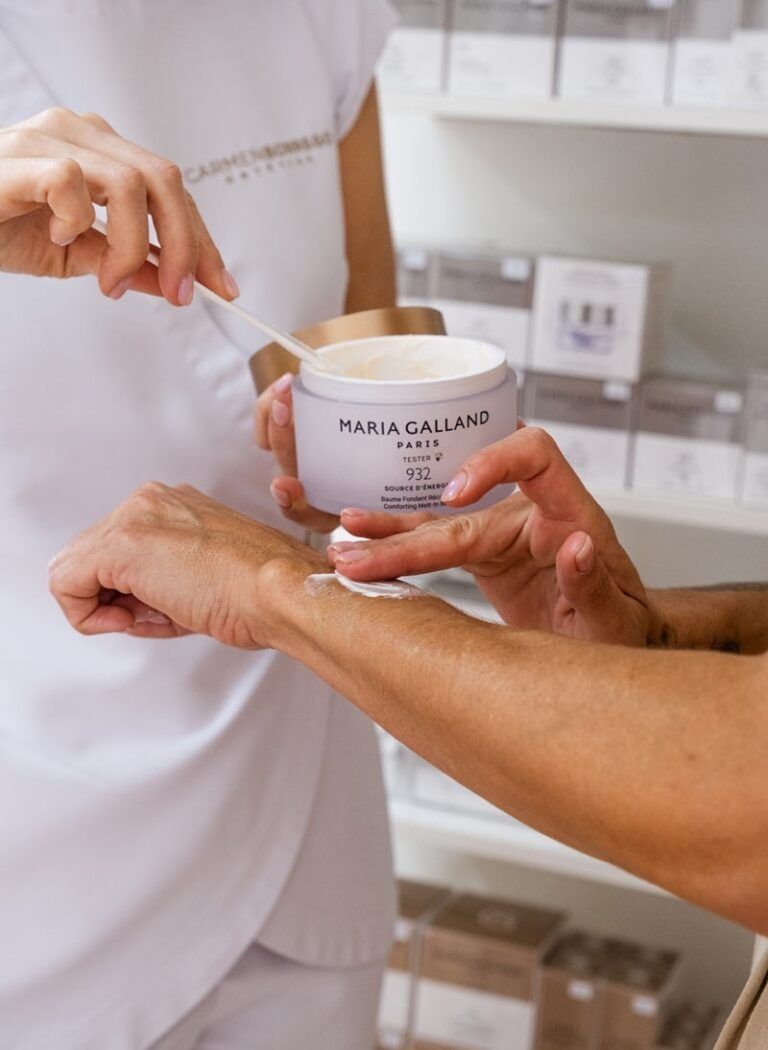 Una persona está aplicando una crema en el brazo de otra persona.