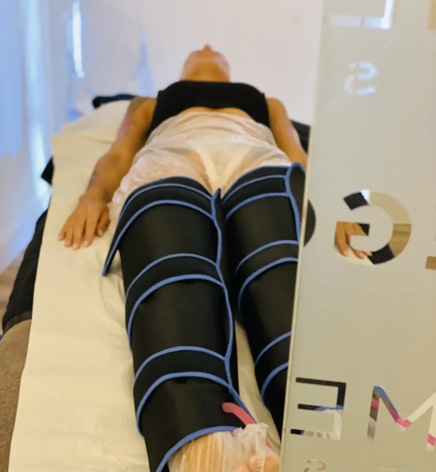 Una mujer está acostada en una cama recibiendo un tratamiento en sus piernas.