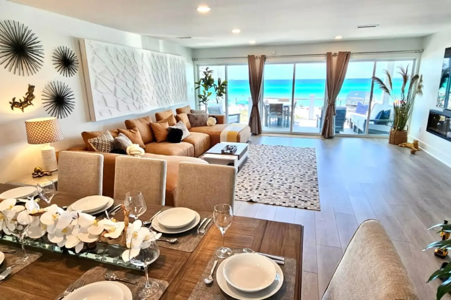 A living room with a dining table and a view of the ocean