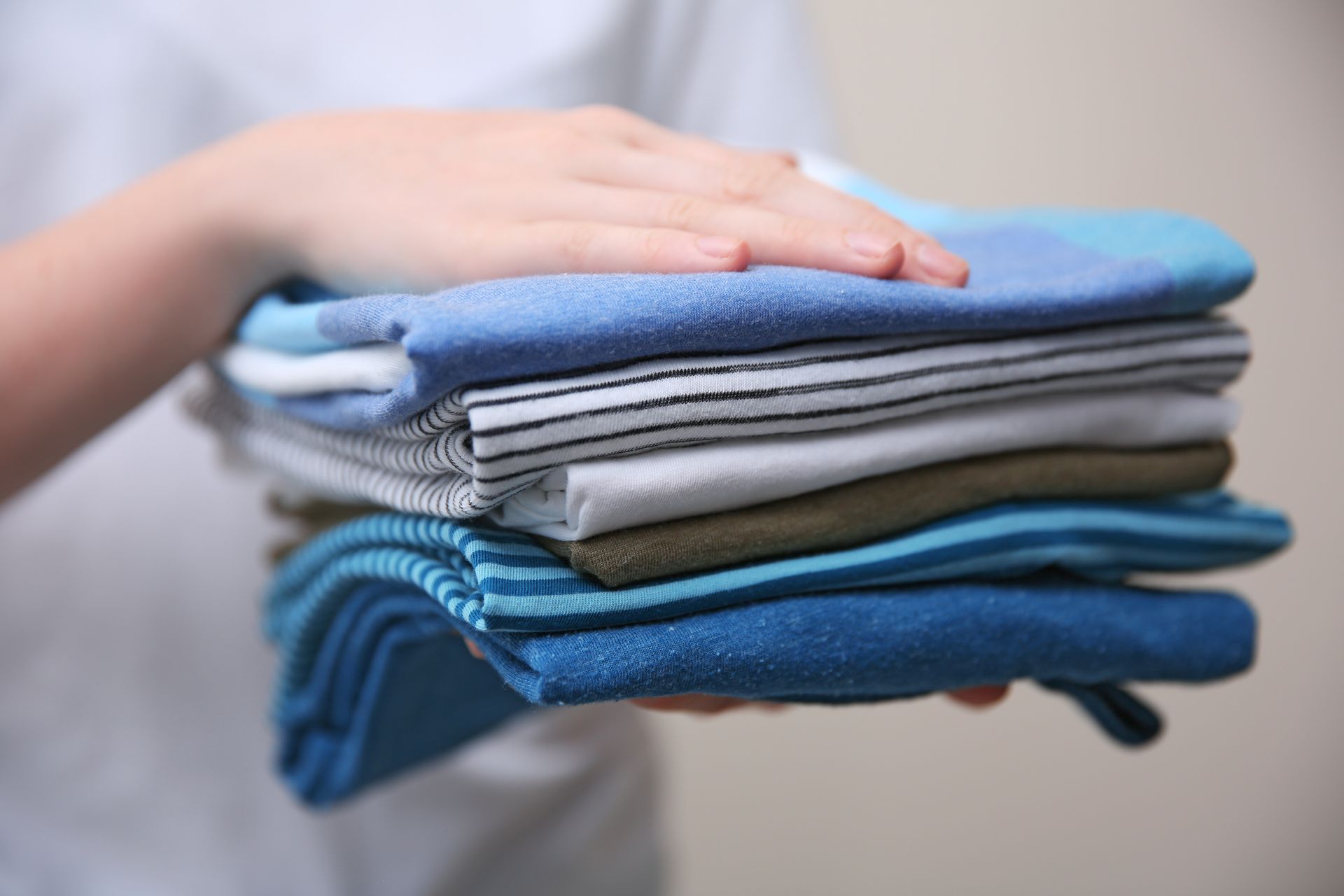 Stapel von Hemden zwischen Händen