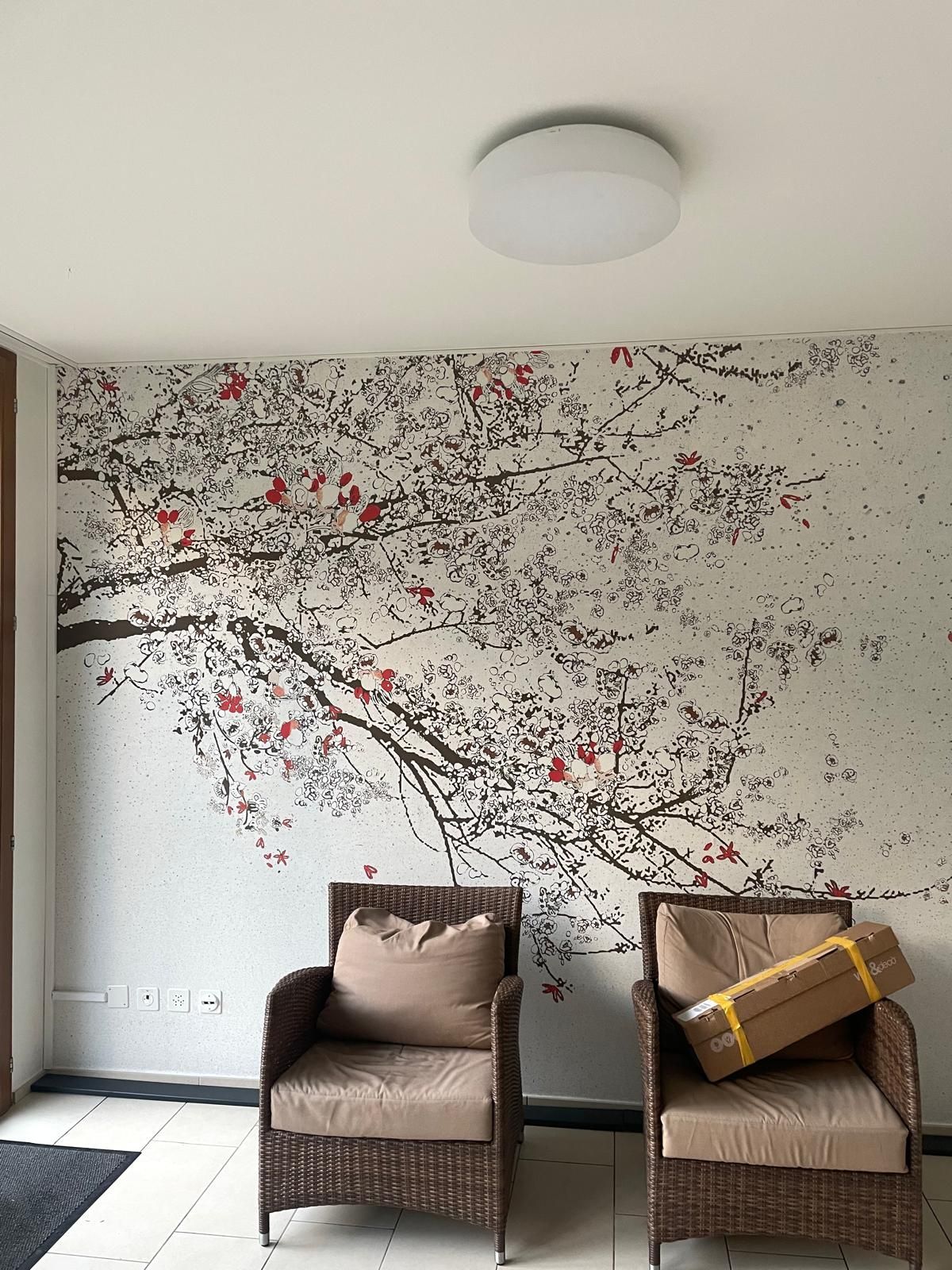 Ein roter Farbspritzer mit kleineren kreisförmigen Tropfen auf weissem Hintergrund.