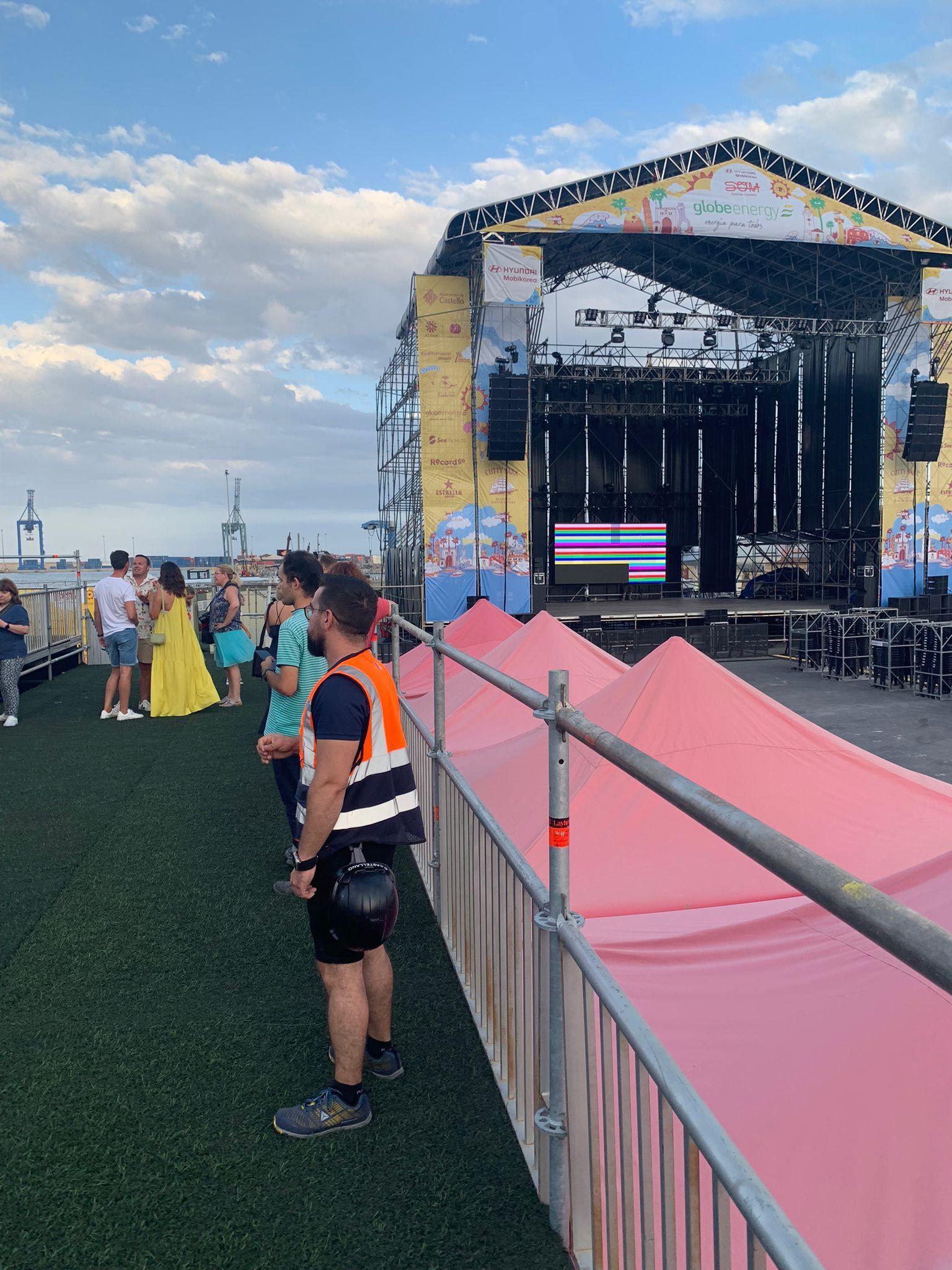 Un hombre está parado frente a un escenario en un concierto.