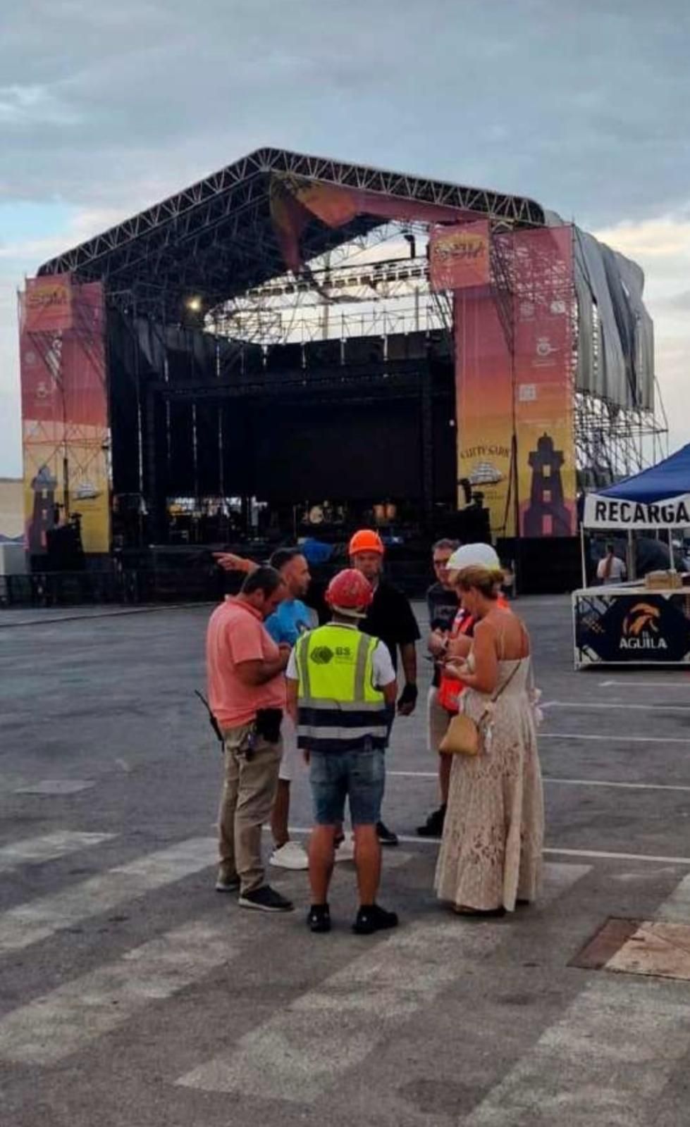 Un grupo de personas está de pie frente a un gran escenario.