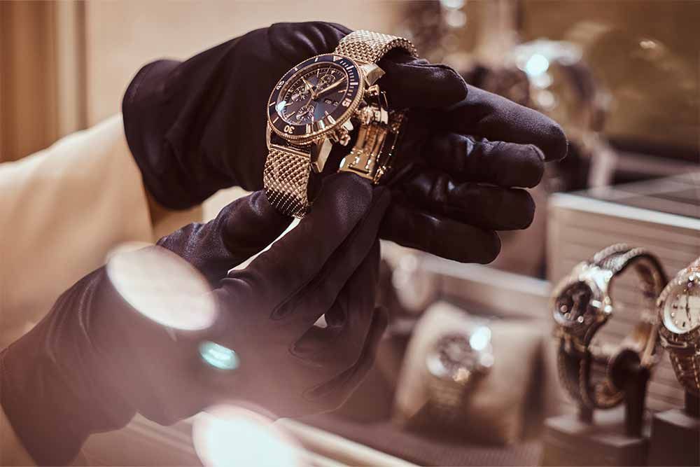 eine Person in Handschuhen hält eine Uhr in der Hand .