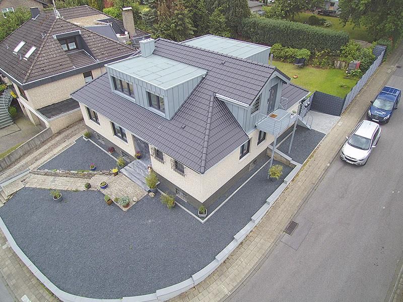 Eine Luftaufnahme eines Hauses mit davor geparkten Autos