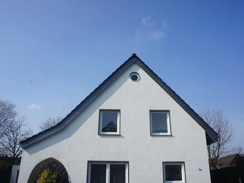 Ein weißes Haus mit einem blauen Himmel im Hintergrund