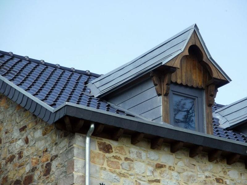 Ein Steingebäude mit einem Dach, auf dem sich ein Fenster befindet