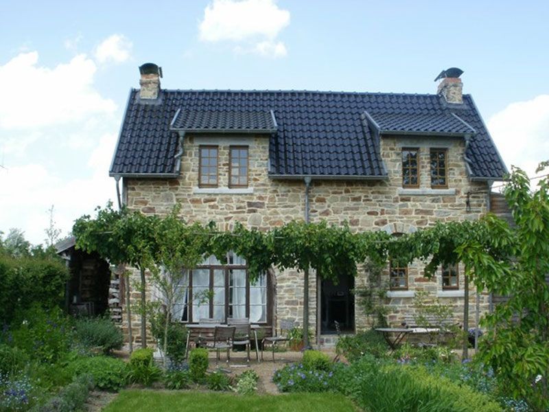 Ein großes Steinhaus mit einem schwarzen Ziegeldach