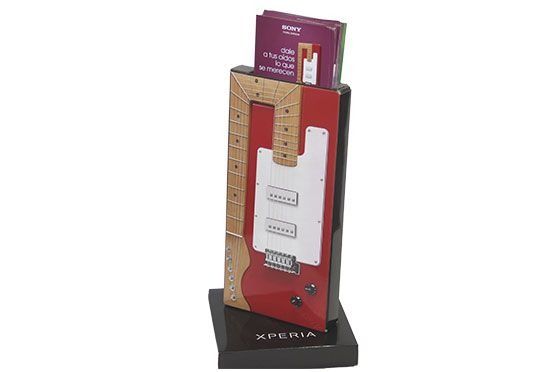 Una exhibición de una guitarra con un libro encima.