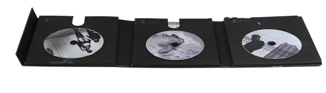 Hay tres CD en una caja negra sobre un fondo blanco.