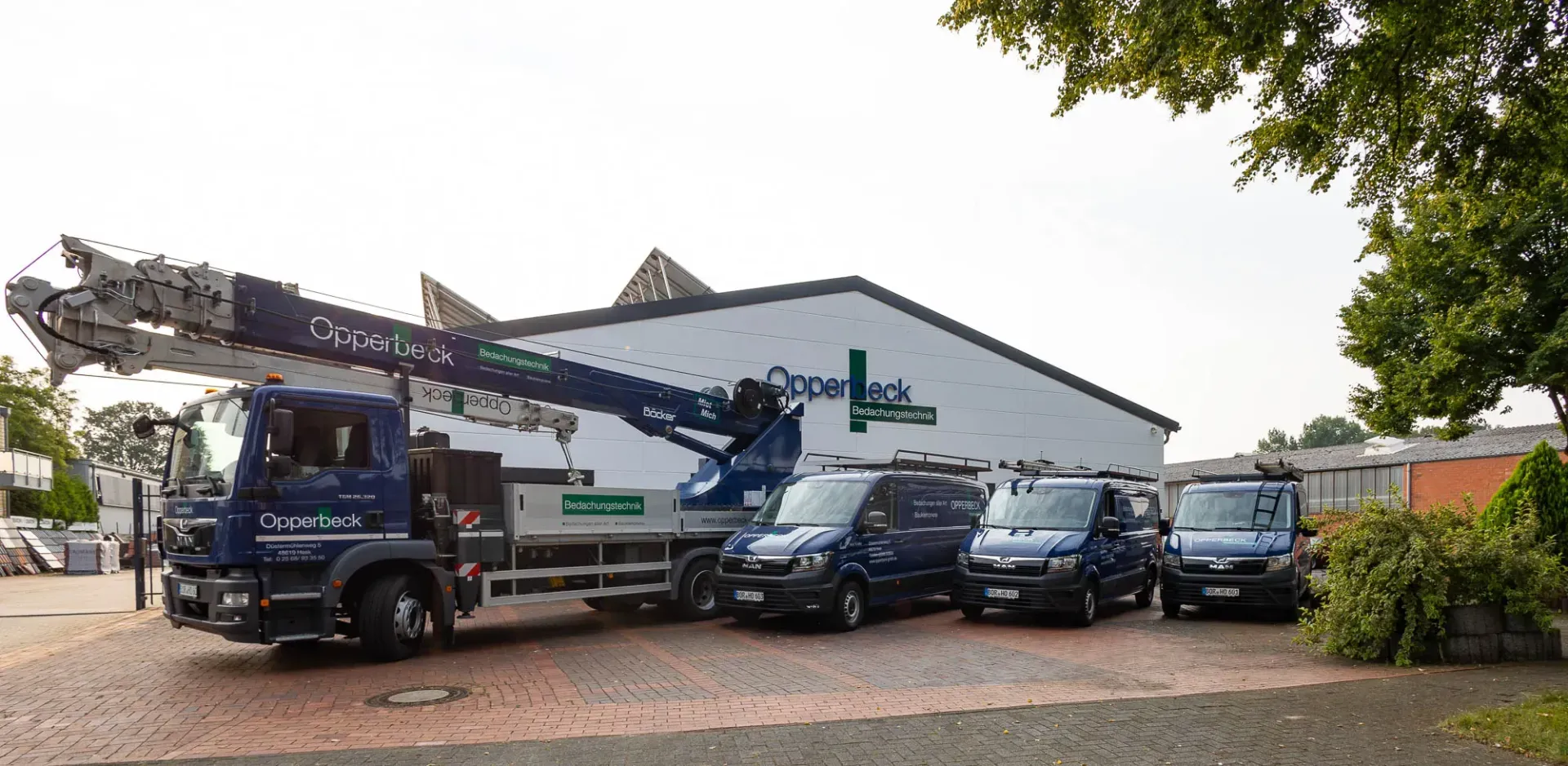 Vor einem Gebäude parken mehrere Lastwagen und Lieferwagen.