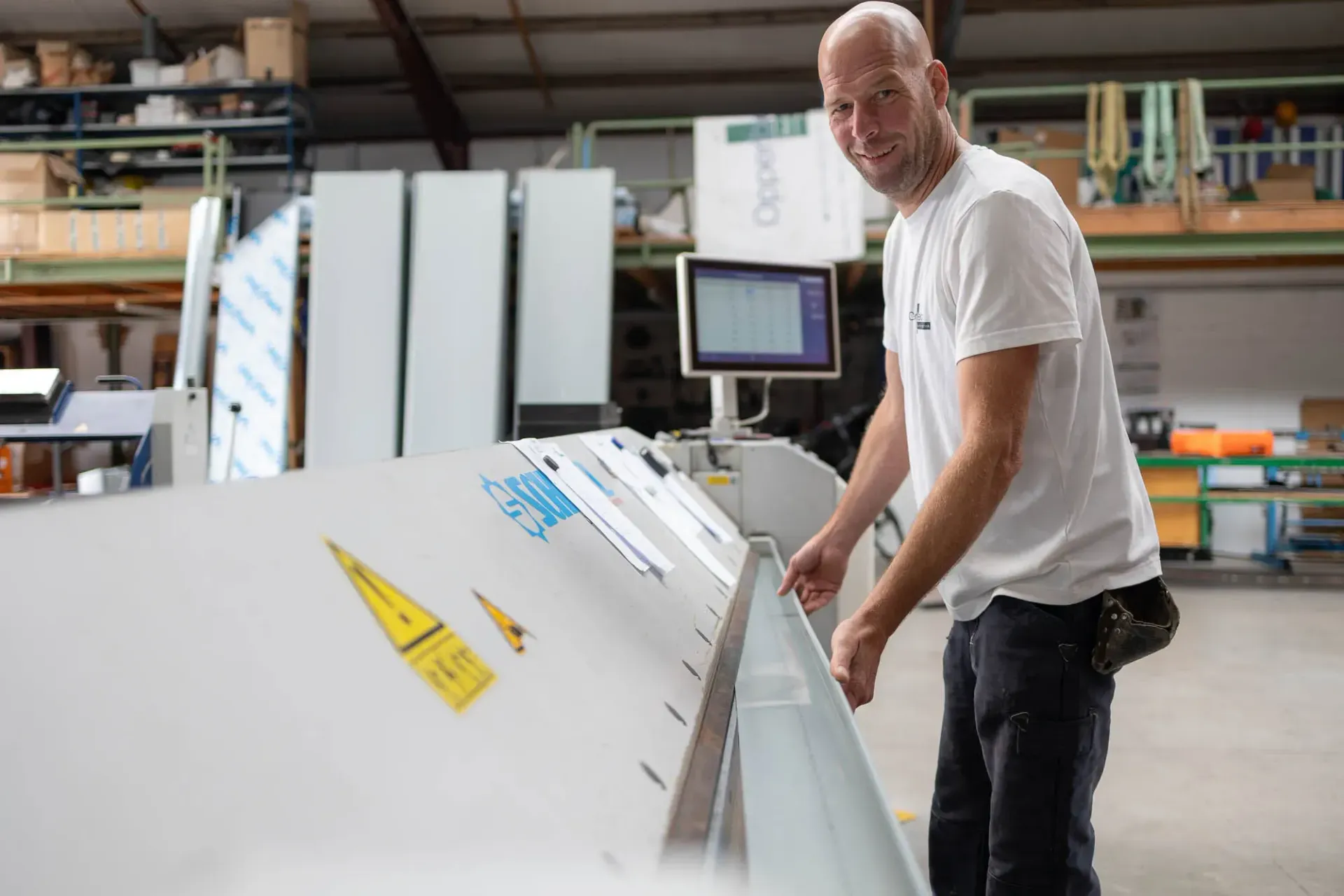 Ein Mann steht vor einer Maschine in einer Fabrik.