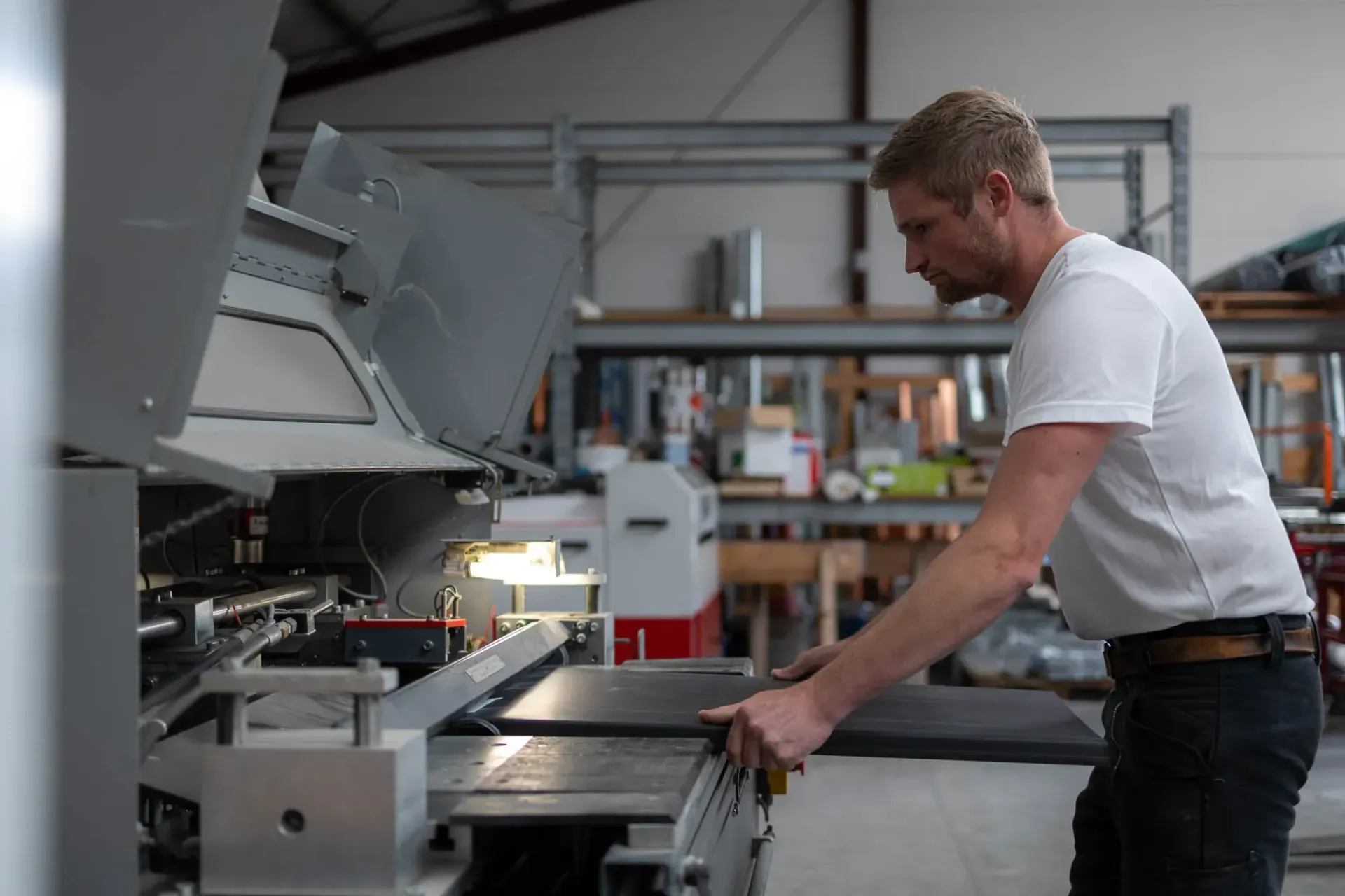 Ein Mann arbeitet in einer Fabrik an einer Maschine.