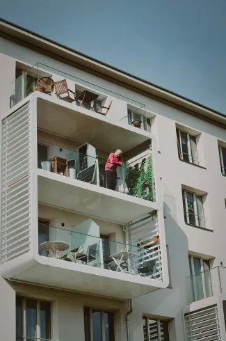 Ein Mann steht auf dem Balkon eines Gebäudes.
