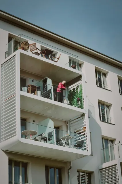 Ein Mann steht auf dem Balkon eines Gebäudes.