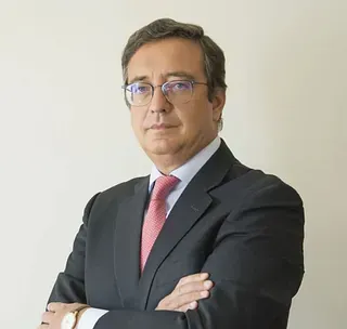 Un hombre con traje y corbata con los brazos cruzados