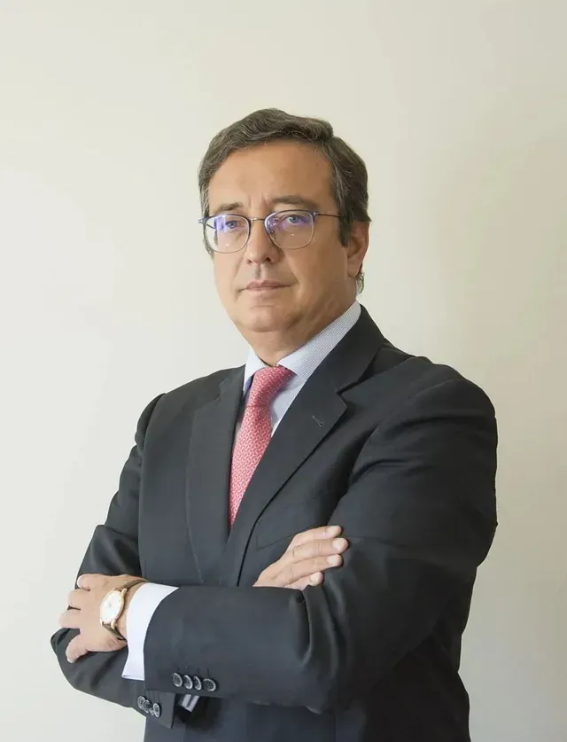 Un hombre con traje y corbata con los brazos cruzados