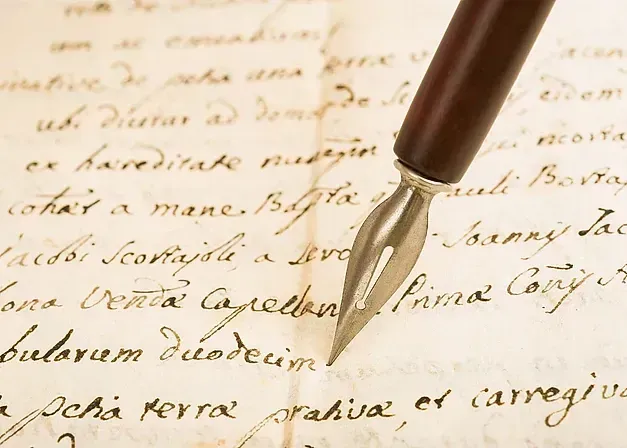 Una pluma estilográfica reposa sobre un trozo de papel escrito a mano