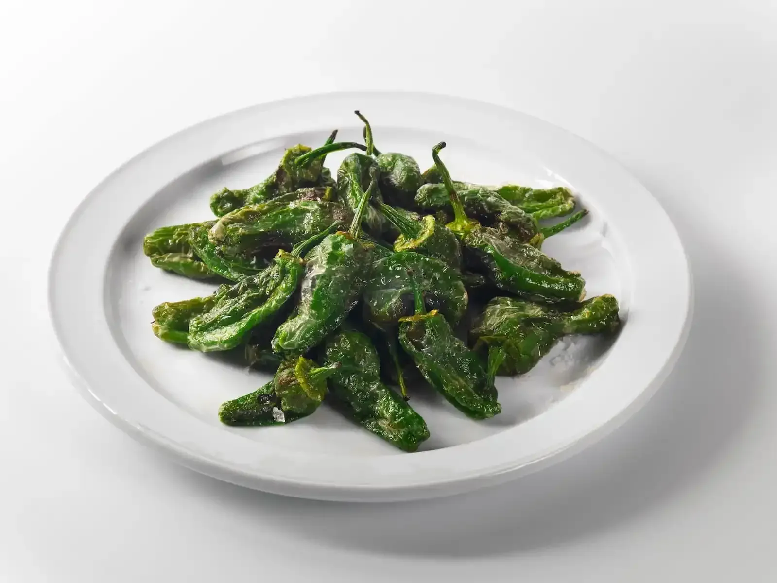 Plato de judías verdes cocidas, ligeramente sazonadas, sobre un plato blanco.
