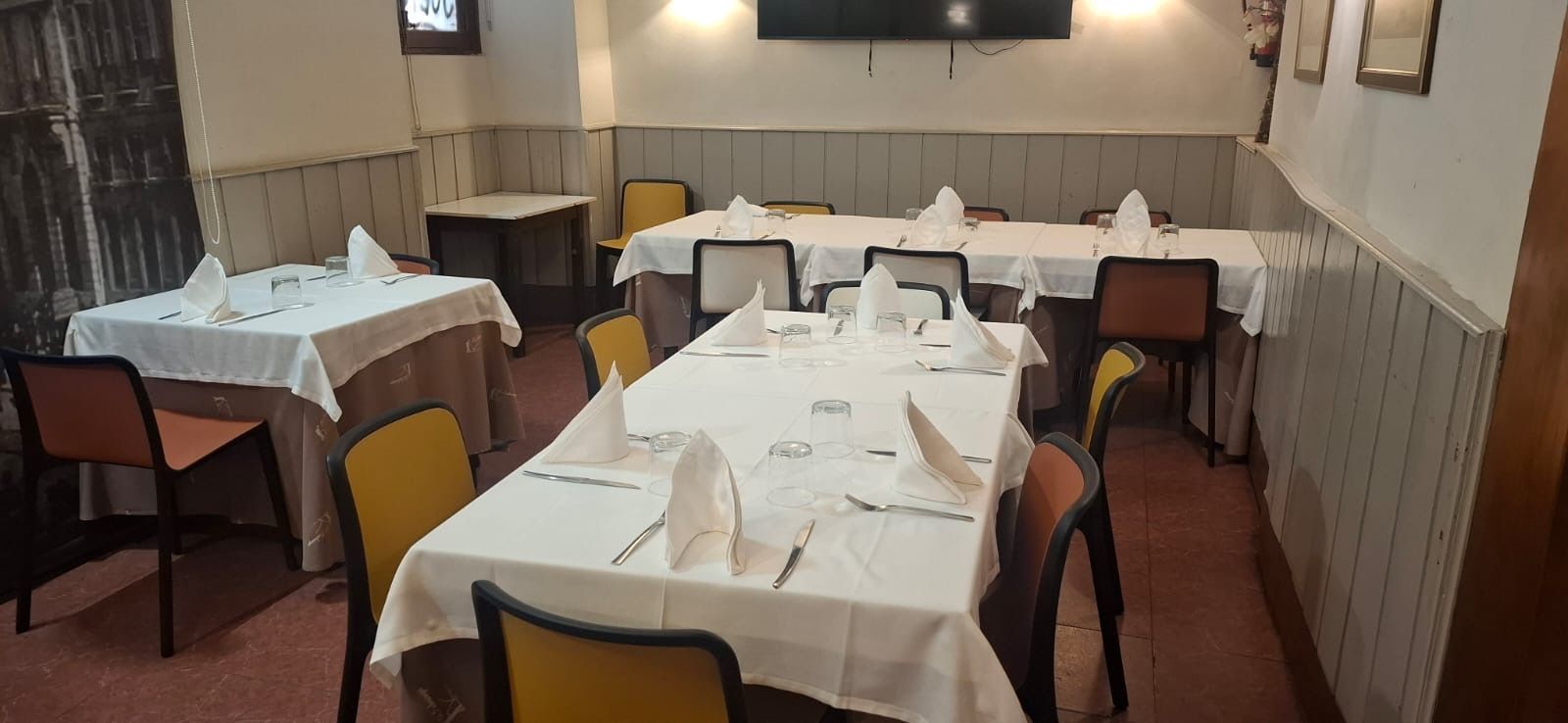 Elegante comedor con mesa redonda, sillas negras e iluminación cálida.