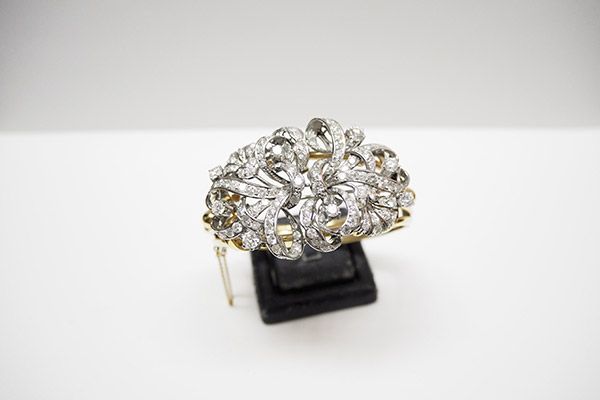 Un anillo está colocado sobre un soporte de exhibición negro sobre una superficie blanca.