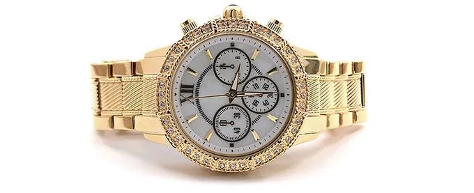 Un reloj de oro con números romanos en la esfera.