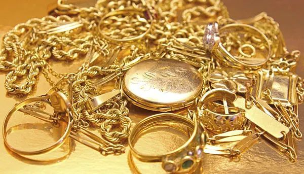 Una pila de joyas de oro está sobre una mesa.