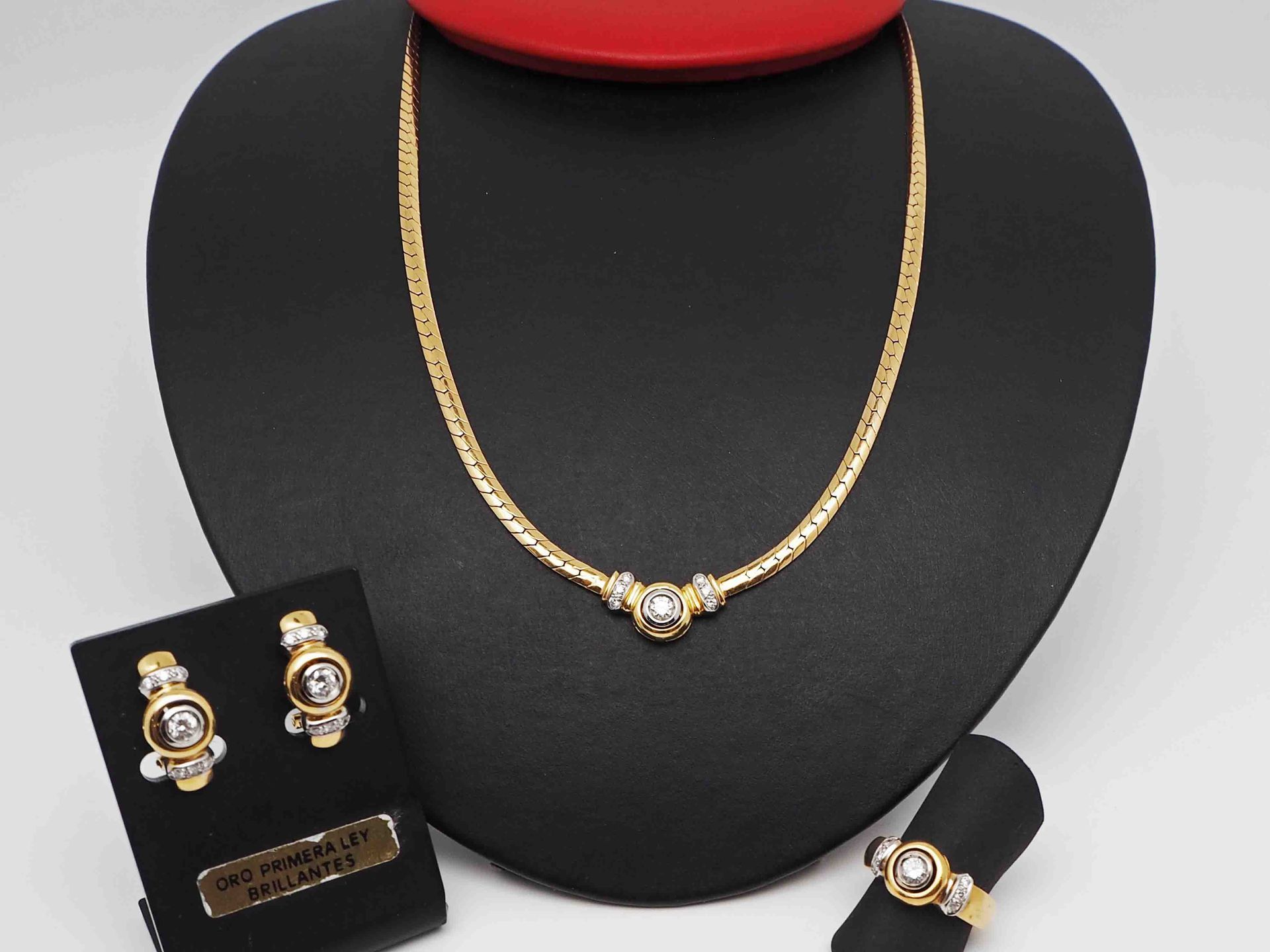 Un collar, unos pendientes y un anillo se exhiben en un maniquí.