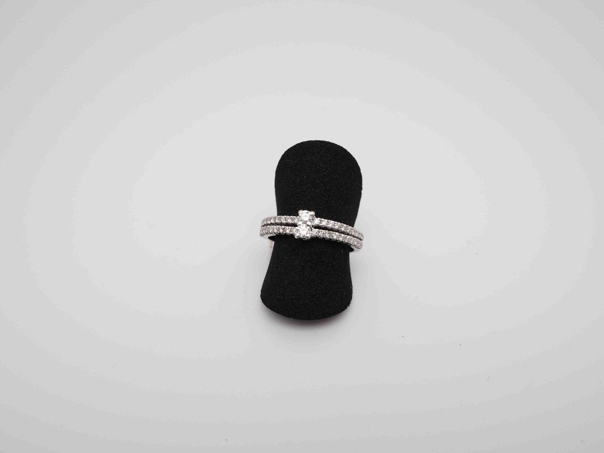 Un anillo está colocado sobre un soporte de anillo negro en un dedo.