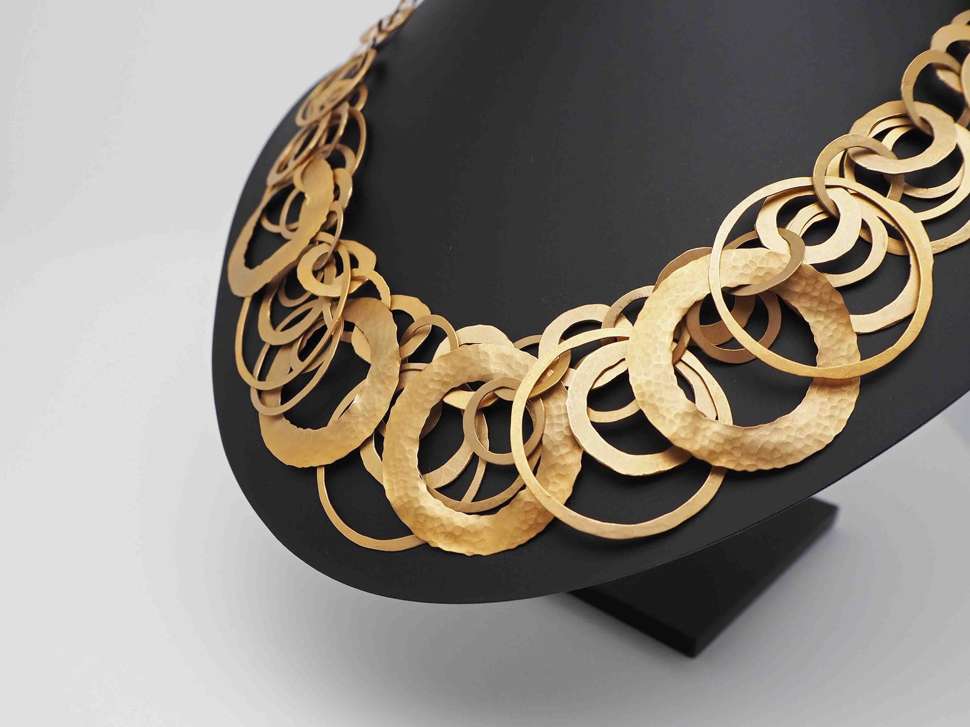 Un primer plano de un collar de oro en un maniquí.