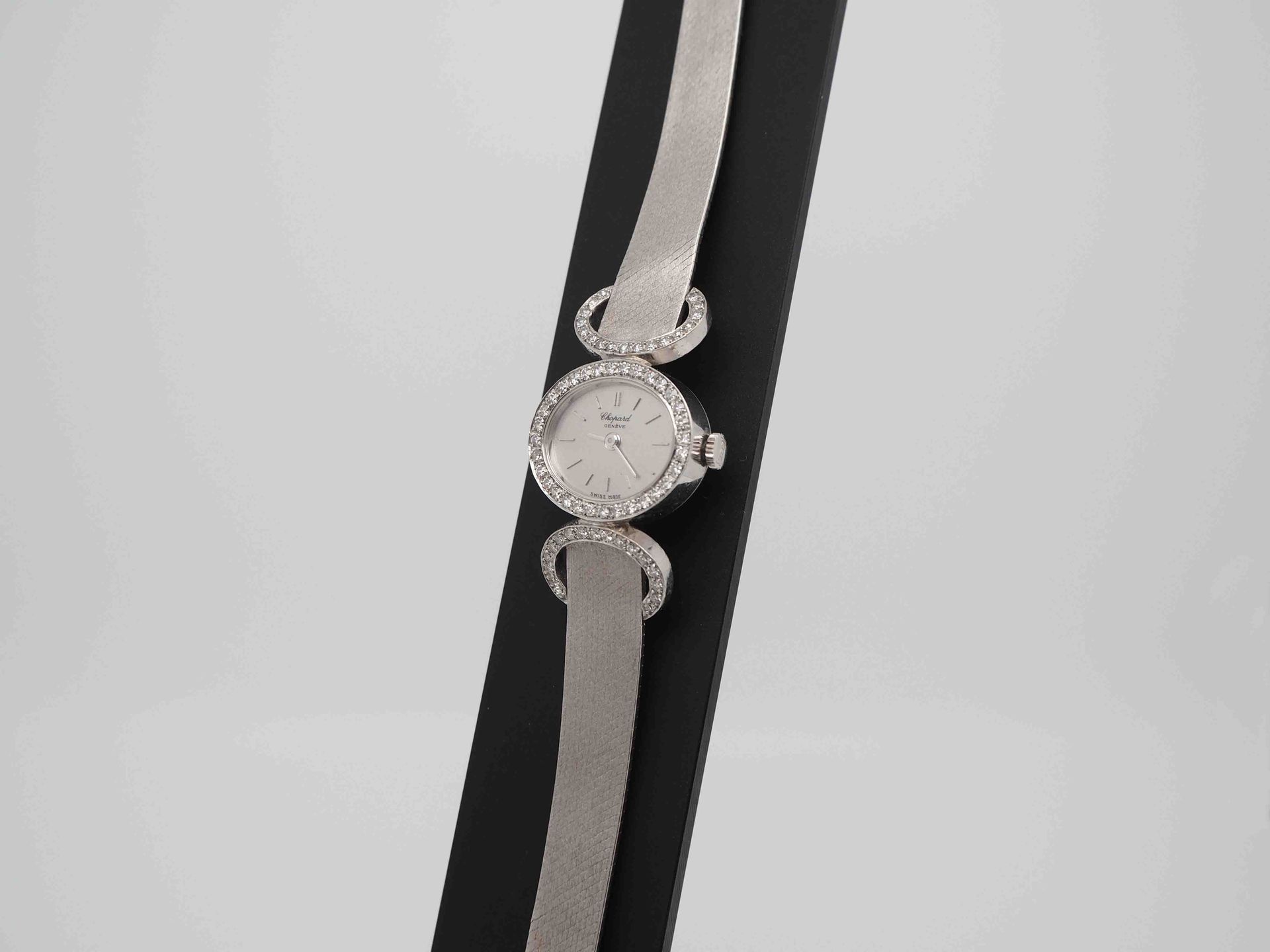 Un reloj de plata con diamantes en la esfera.