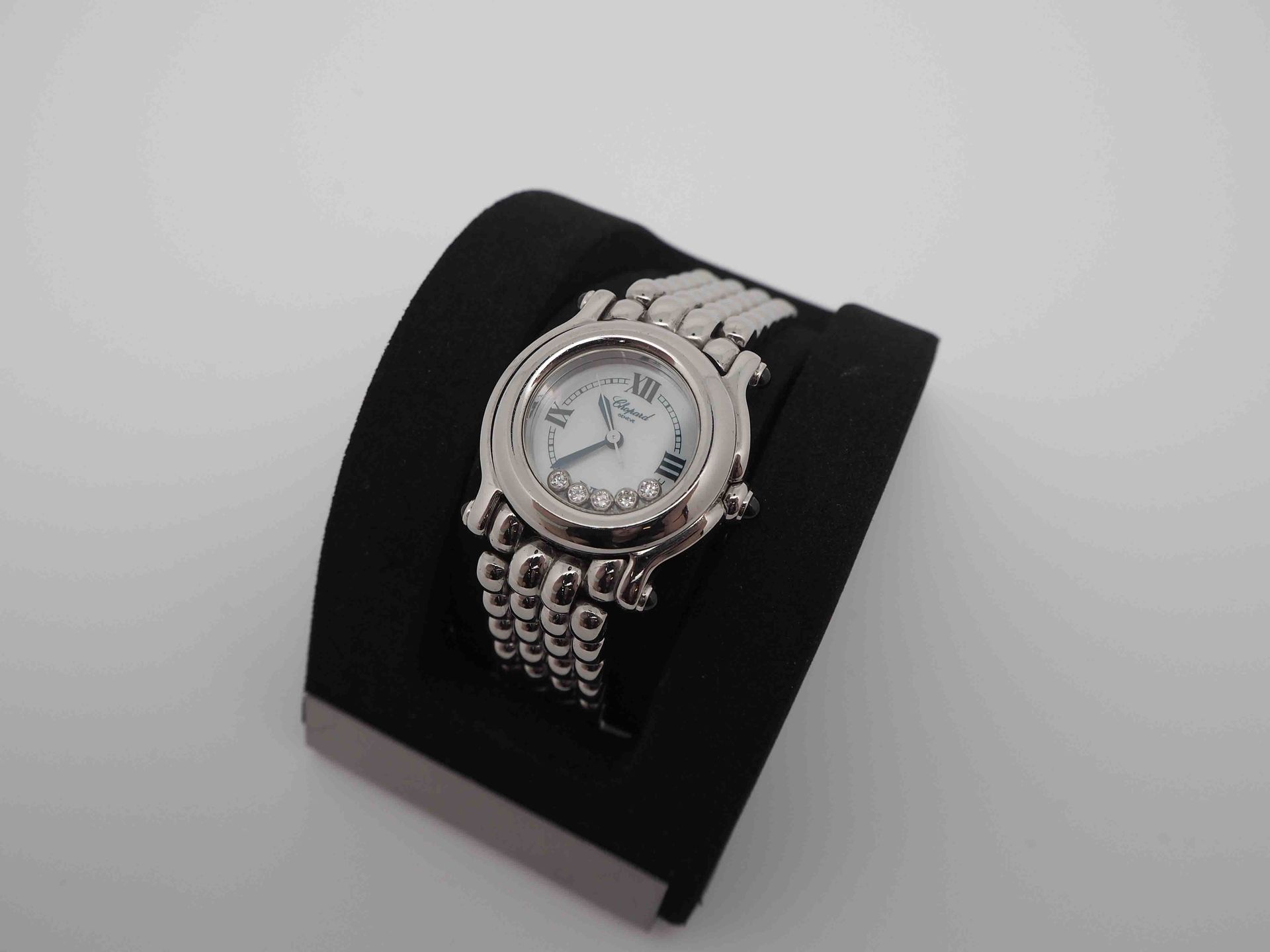 Un reloj Chopard está sobre un cojín negro.