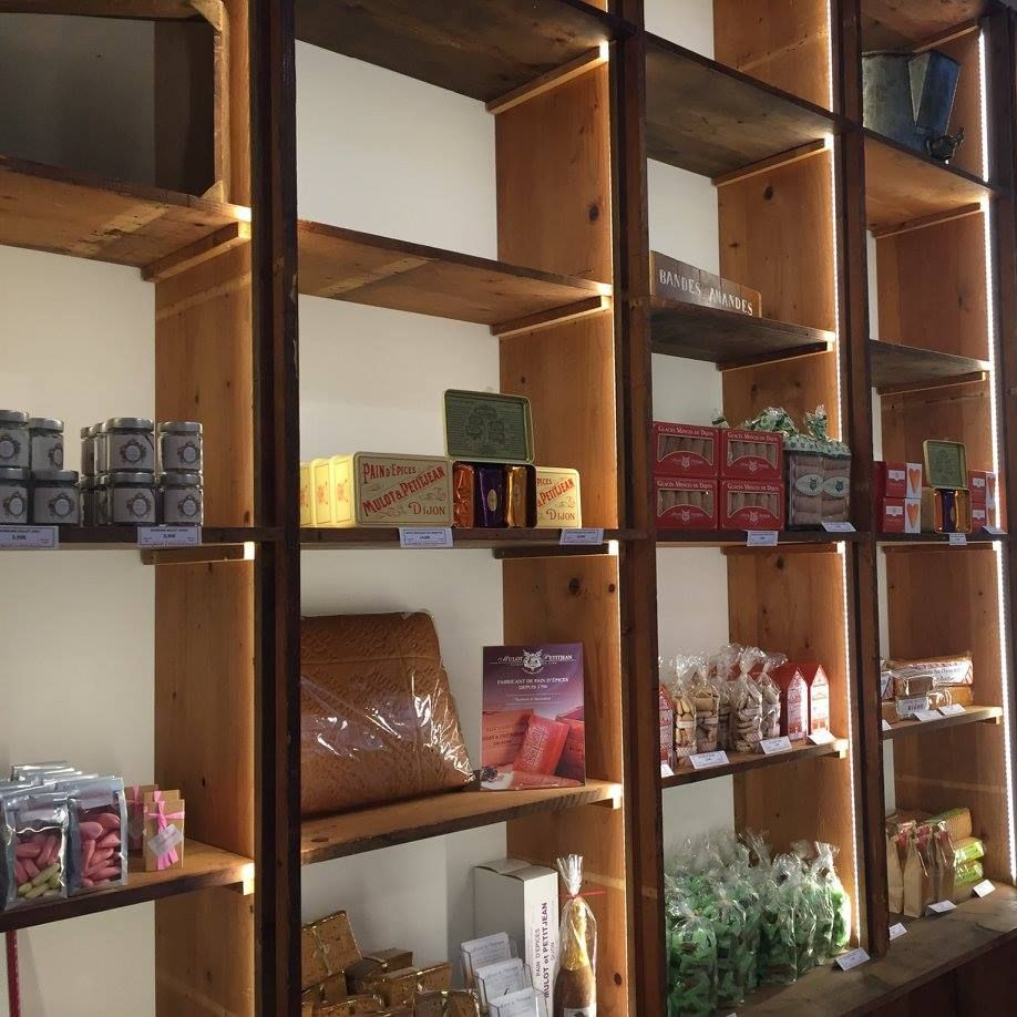 Des étagères en bois garnies de divers produits emballés dans un magasin.