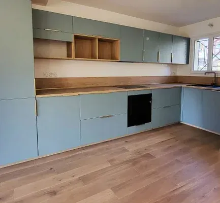 Cuisine moderne avec placards bleu clair, comptoirs en bois et parquet.