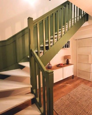 Escalier peint en vert avec marches blanches, parquet et armoire blanche.