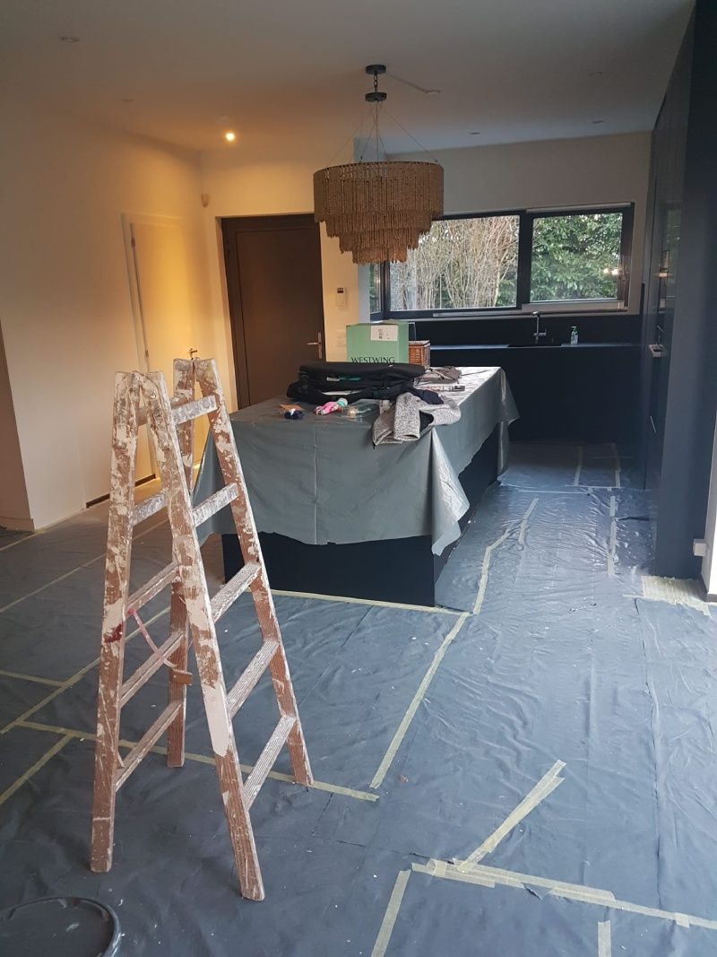 Une échelle en bois est posée dans une pièce à côté d'une table.