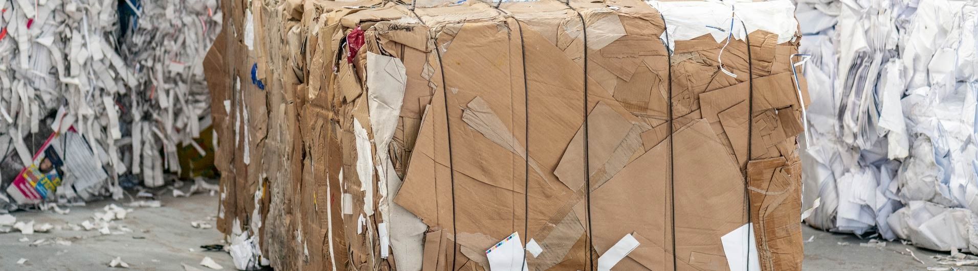 Una pila de cajas de cartón junto a una pila de papel triturado.