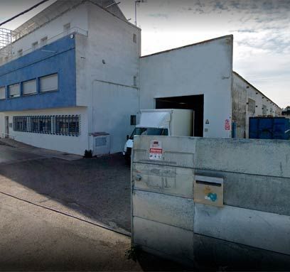 Un edificio azul y blanco con un camión estacionado enfrente.